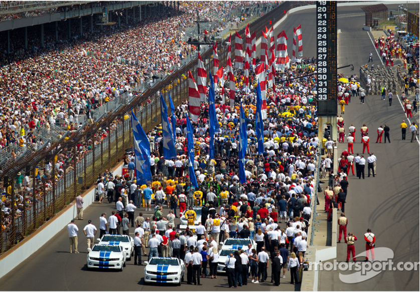 Race cars and crew preparing on the track before a big race.