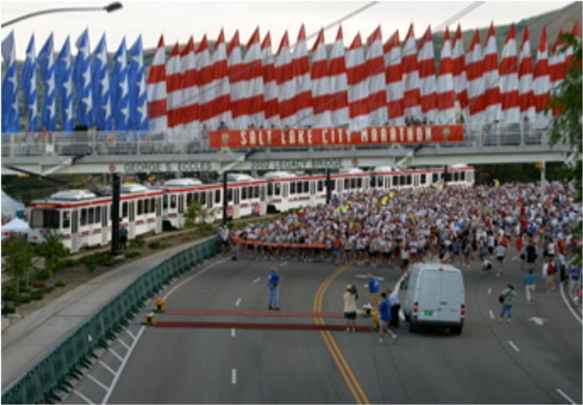Crowd gathered under American flags at a public event with a police presence.