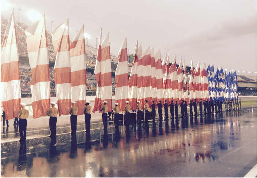 Soldiers holding striped flags in a ceremonial formation.